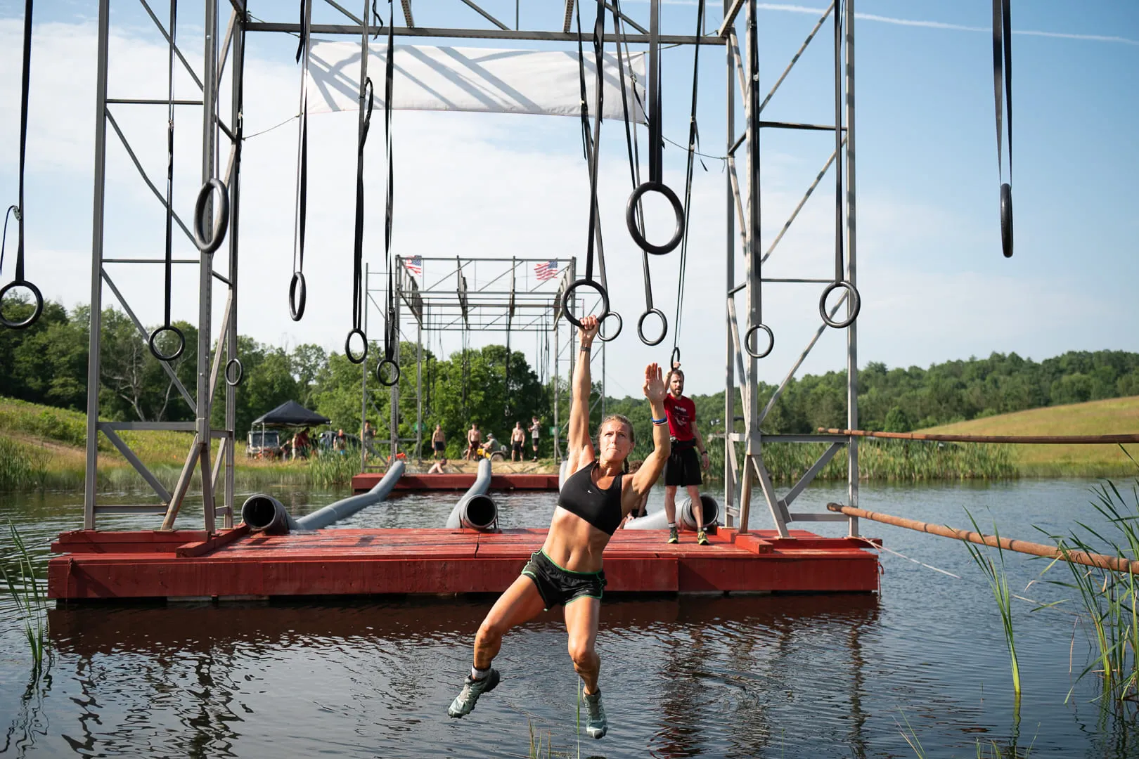 Athlete navigating rings suspended over water in the WarX 5K race.
